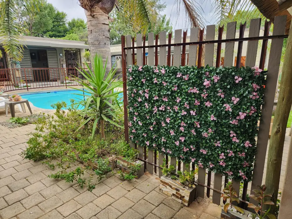 Pink floral hedge privacy screen beside pool