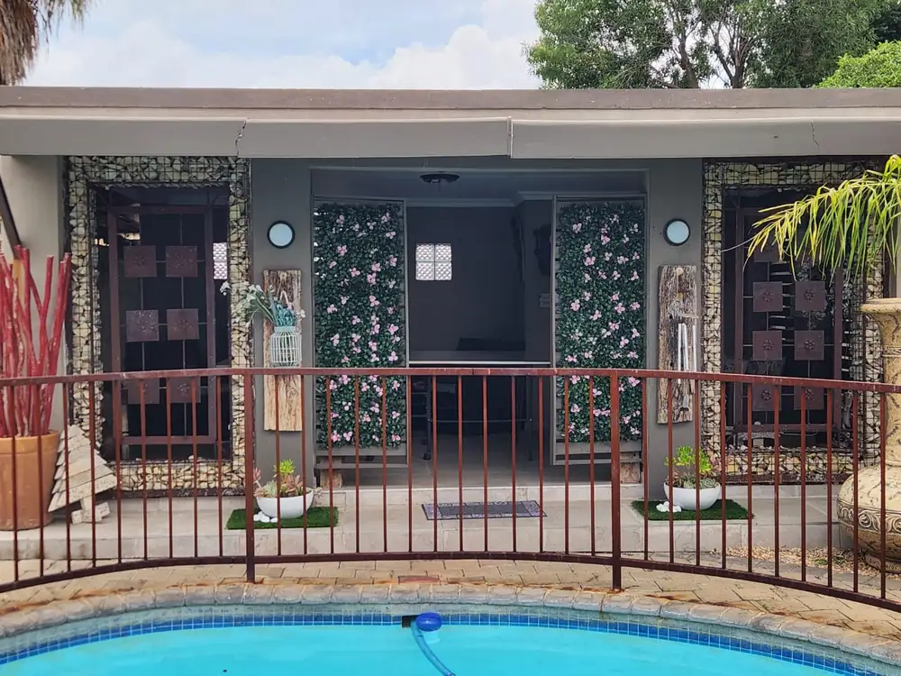 Poolside entrance with pink floral hedge panels