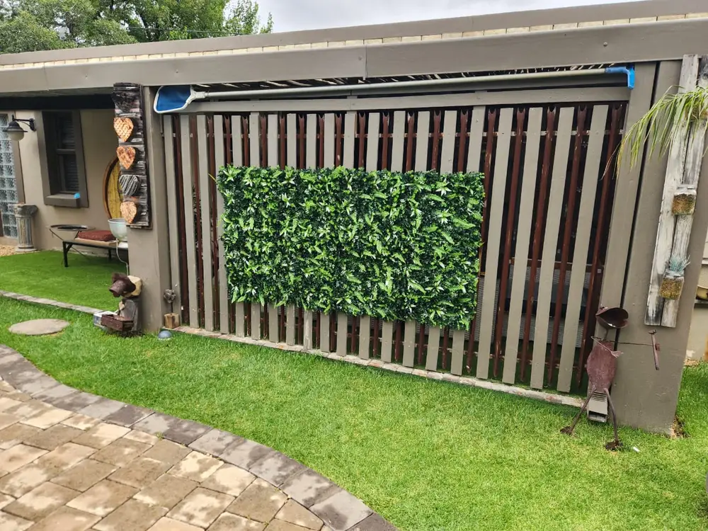 Green artificial hedge feature panel on slatted wall